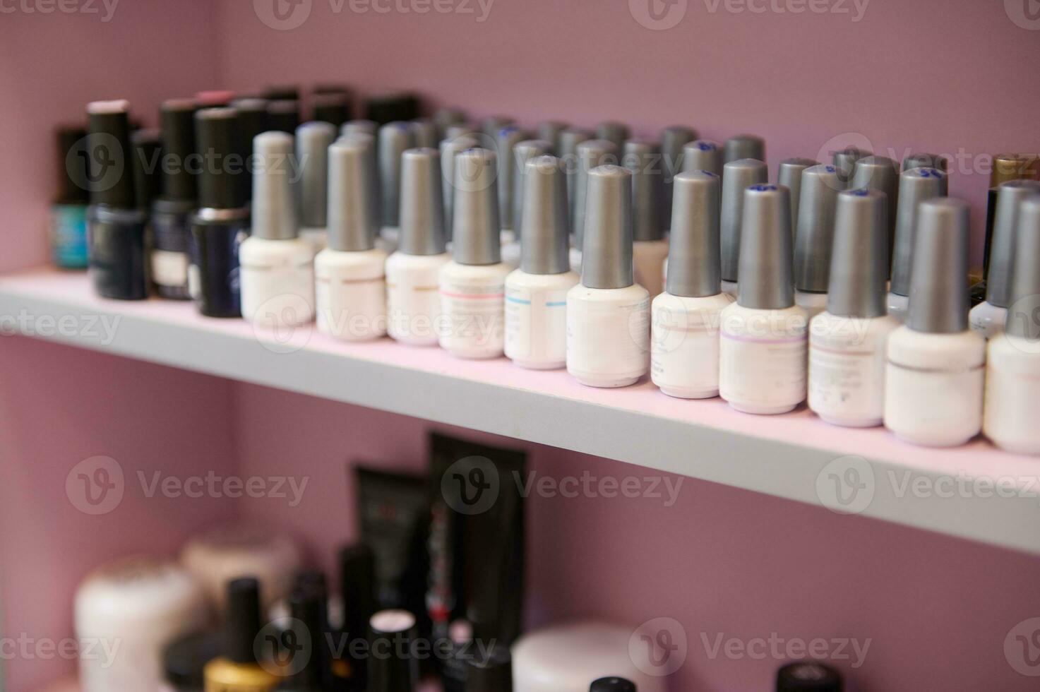 Close-up of many jars of nail polish of different colors on the shelf photo