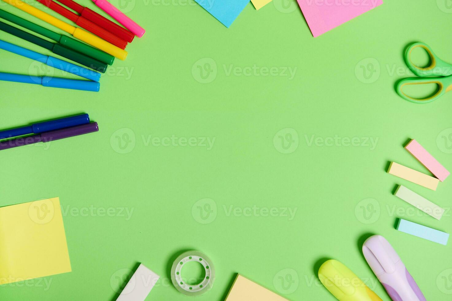Flat lay composition with stationery office or school supplies scattered in a circle on a light green background with copy space. Teacher's day concept photo