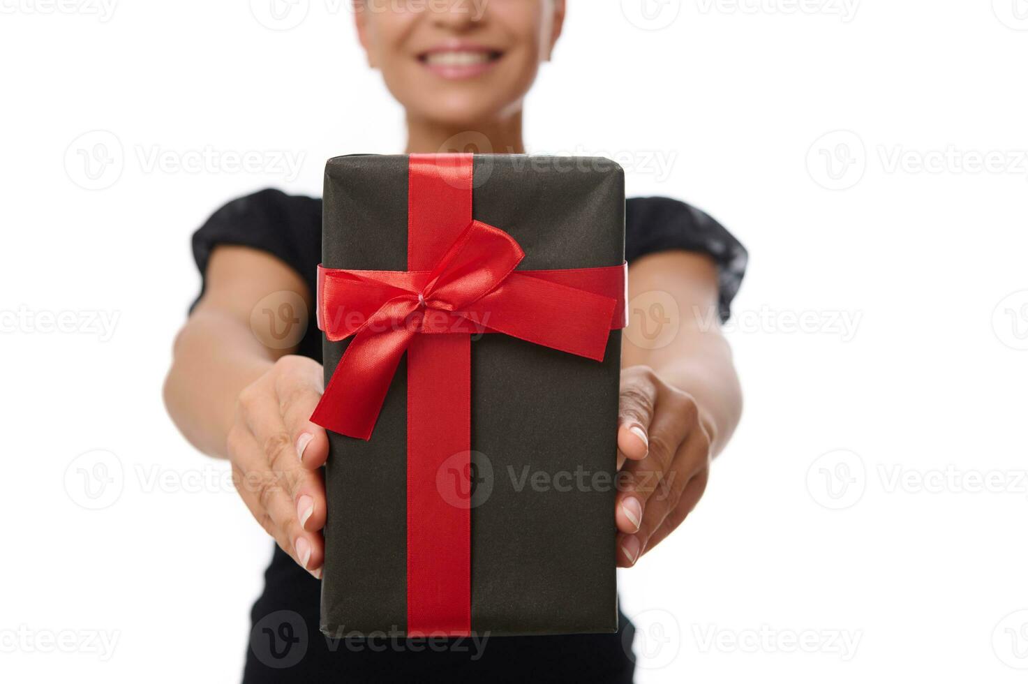 de cerca de un negro regalo caja con rojo cinta en el manos de sonriente mujer aislado en blanco antecedentes con Copiar espacio. aniversario, negro viernes y celebracion concepto foto