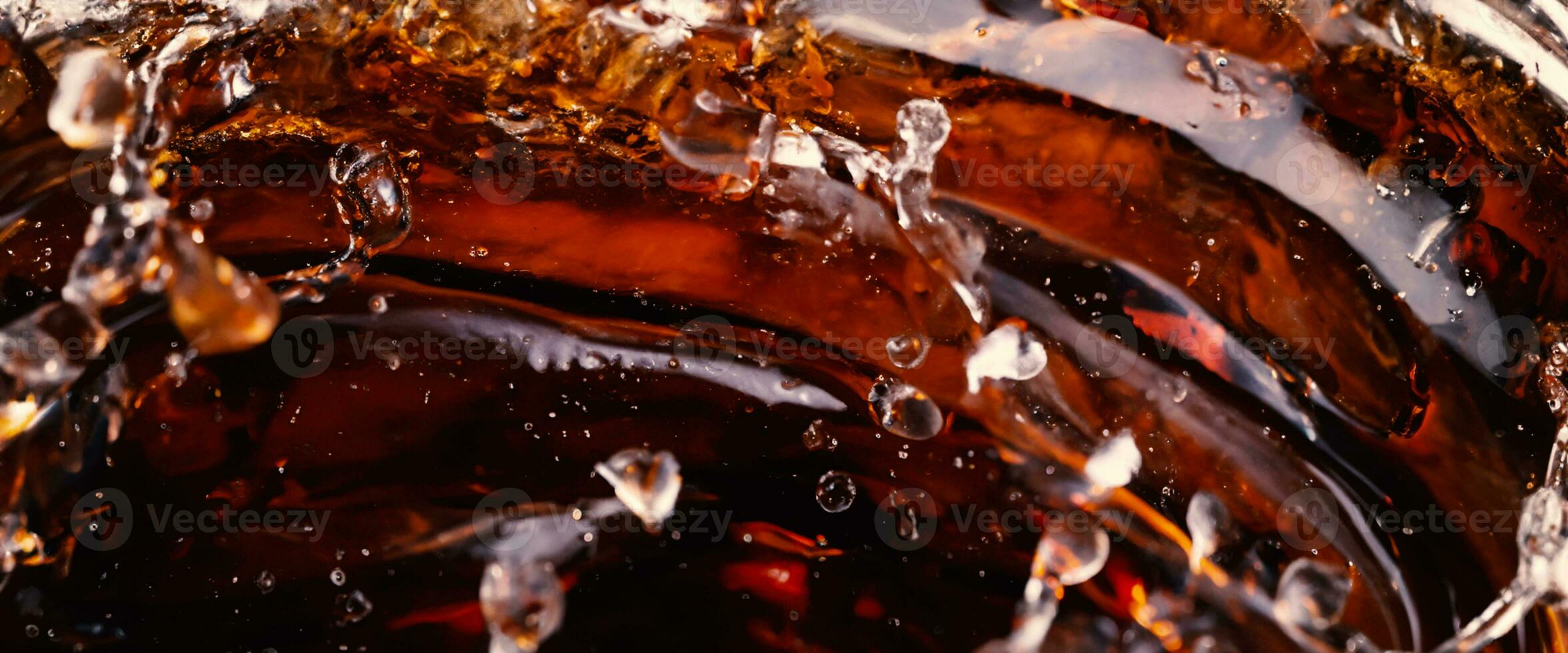 Splashing of Cola and Ice. Cola soda and ice splashing fizzing or floating up to top of surface. Close up of ice in cola water. Texture of carbonate drink with bubbles in glass. Cold drink background photo