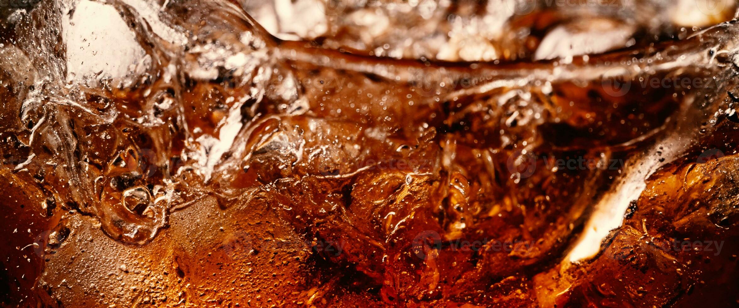 Splashing of Cola and Ice. Cola soda and ice splashing fizzing or floating up to top of surface. Close up of ice in cola water. Texture of carbonate drink with bubbles in glass. Cold drink background photo