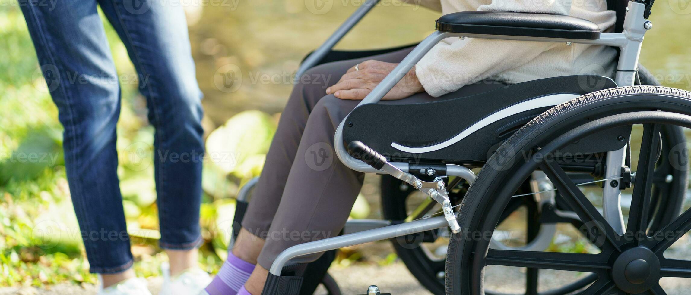 enfermería hogar. joven cuidador Ayudar mayor mujer en silla de ruedas. foto