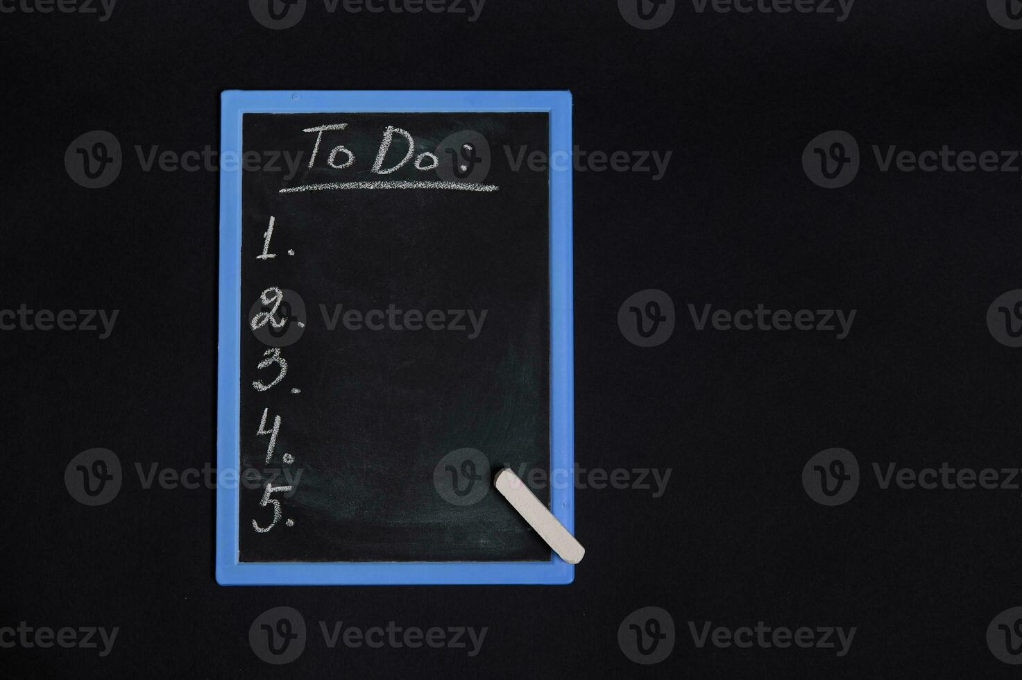 Flat lay of a chalk board with lettering list to do, with empty copy space. Isolated on black background. Planning concepts, time management, timetable and timing. photo