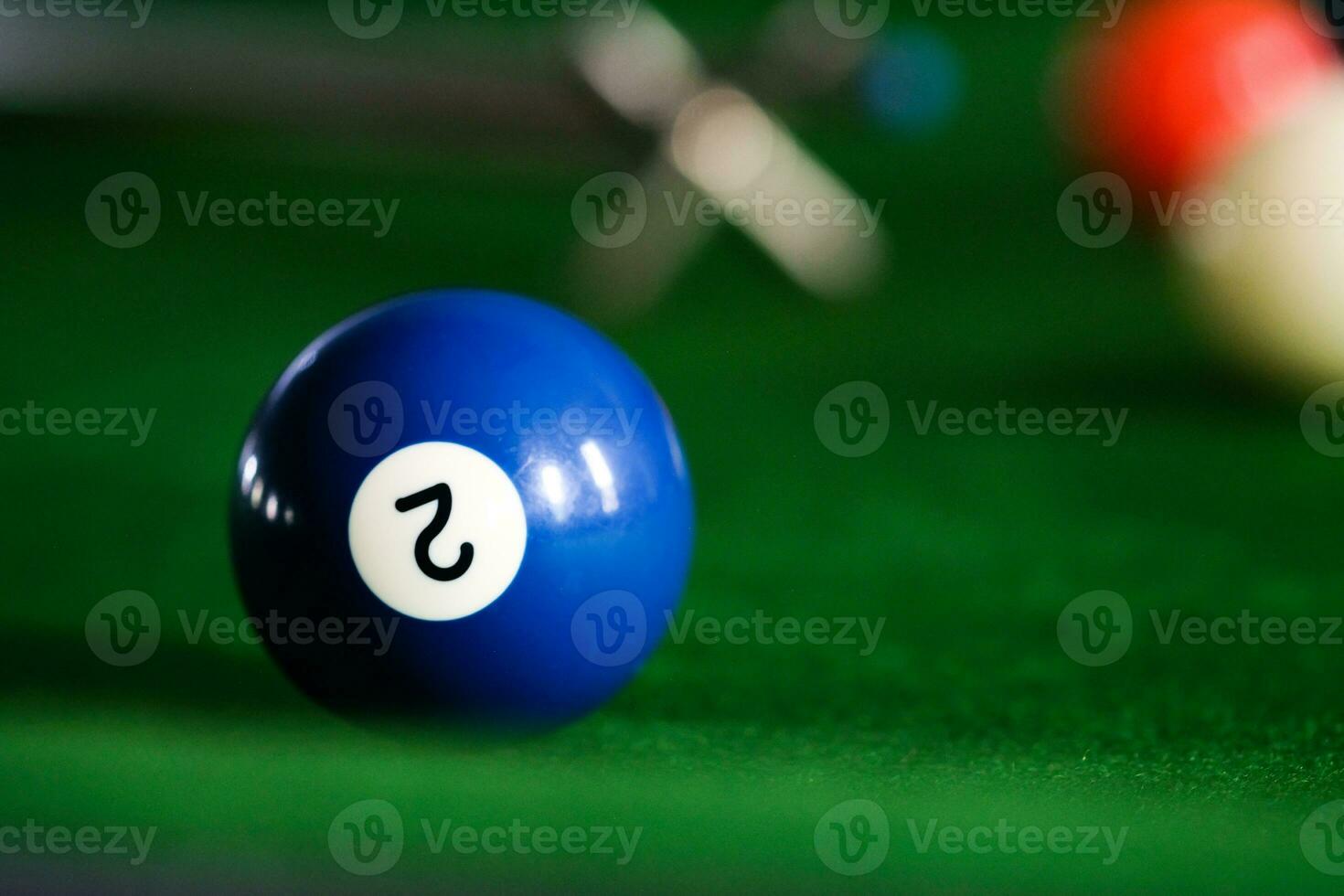 Man's hand and Cue arm playing snooker game or preparing aiming to shoot pool balls on a green billiard table. Colorful snooker balls on green frieze. photo