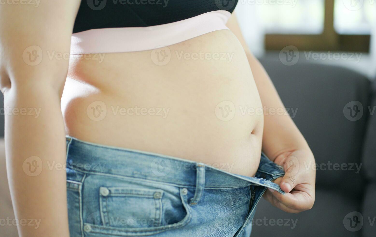 obeso mujer con grasa trastornado acerca de su barriga. exceso de peso mujer conmovedor su grasa barriga y querer a perder peso. grasa mujer con apretado ropa preocupado acerca de peso dieta estilo de vida concepto foto