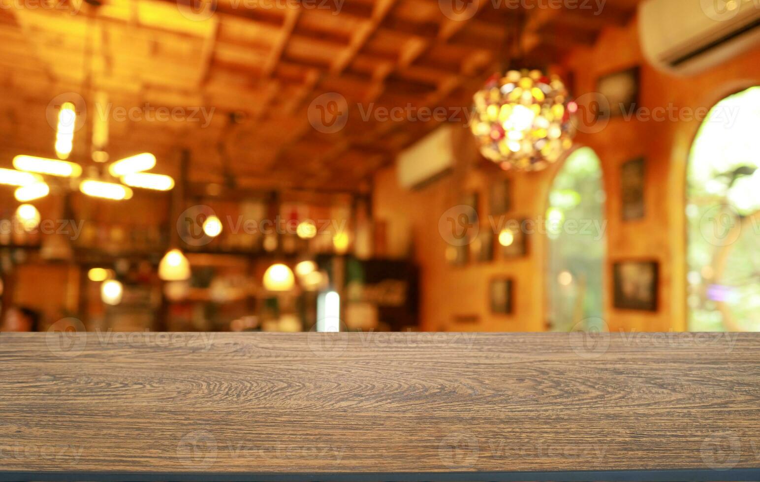 vacío de madera mesa en frente de resumen borroso antecedentes de café tienda . lata ser usado para monitor o montaje tu productos.mock arriba para monitor de producto foto