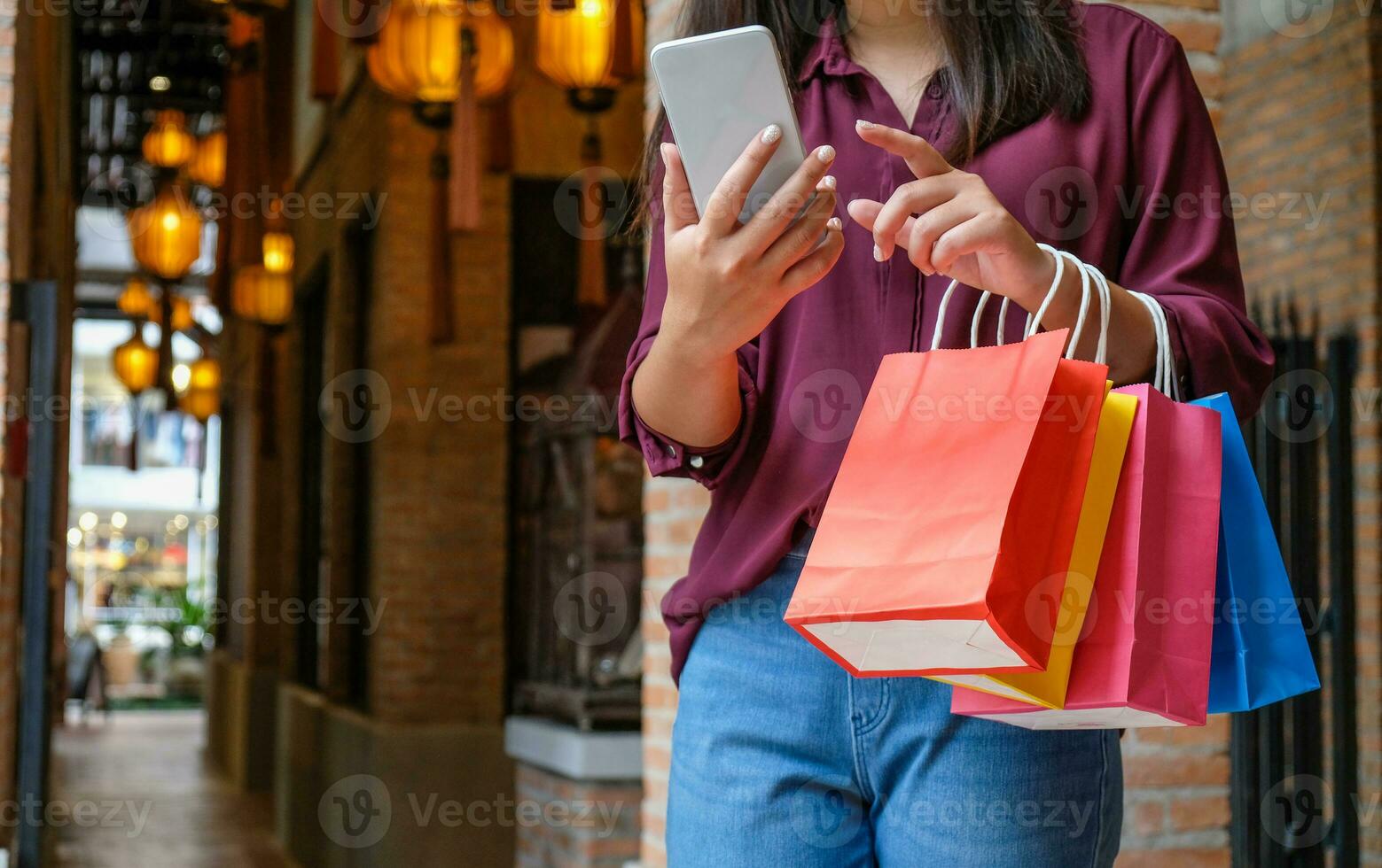 asiático muchachas participación rebaja compras bolsas. consumismo estilo de vida concepto en el compras centro comercial. dama turista caminar compras centrar con compras pantalones foto