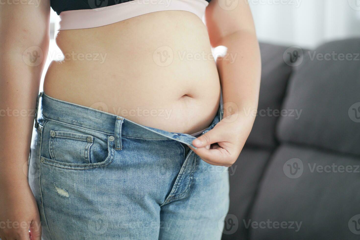 Obese Woman with fat upset about her belly. Overweight woman touching his fat belly and want to lose weight. Fat woman with tight clothing worried about weight diet lifestyle concept photo