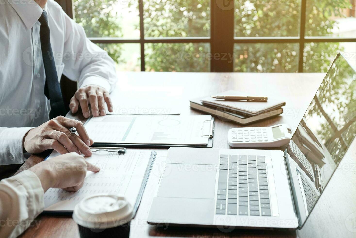 Businessman analyzing investment charts and pressing calculator buttons over documents. Accounting Concept. photo