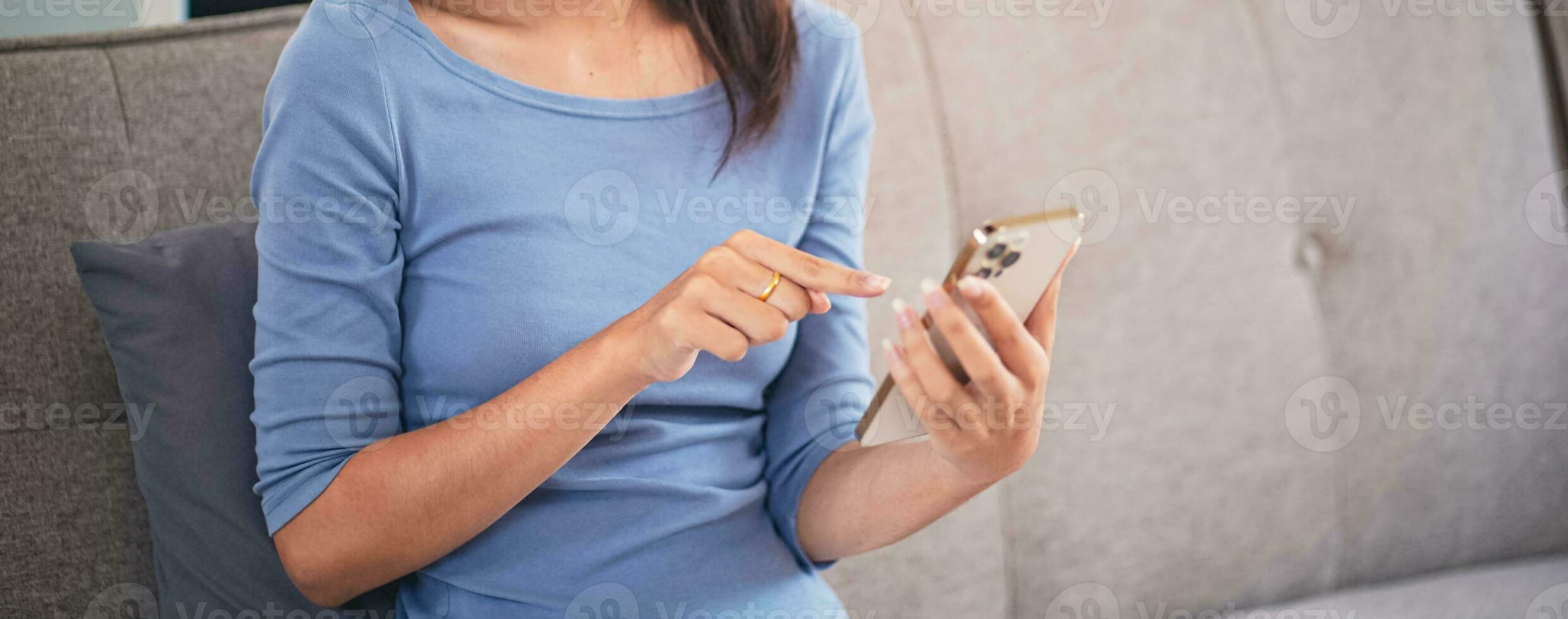 Asian Woman controlling smart home. mobile phone with smart home app in living room. touch screen ai technology. Remote home control system photo