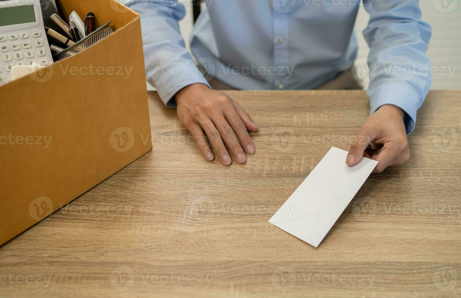 sending resignation letter to boss and Holding Stuff Resign Depress or carrying cardboard box by desk in office photo