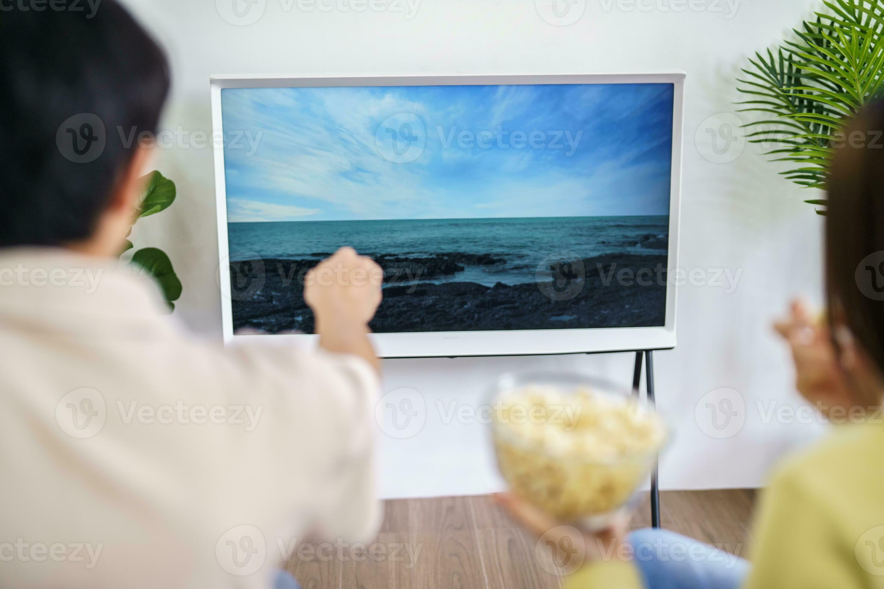 Asian family Watching smart TV together and using remote
