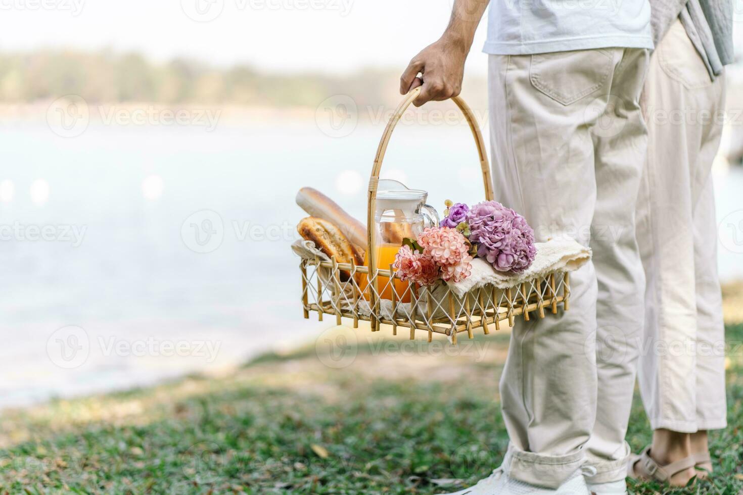 Couple walking in garden with picnic basket. in love couple is enjoying picnic time in park outdoors photo