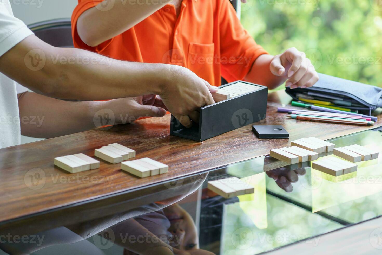 Asian father and son playing wood blocks game Carefree kid playing wood blocks game building constructor from blocks with father at home photo