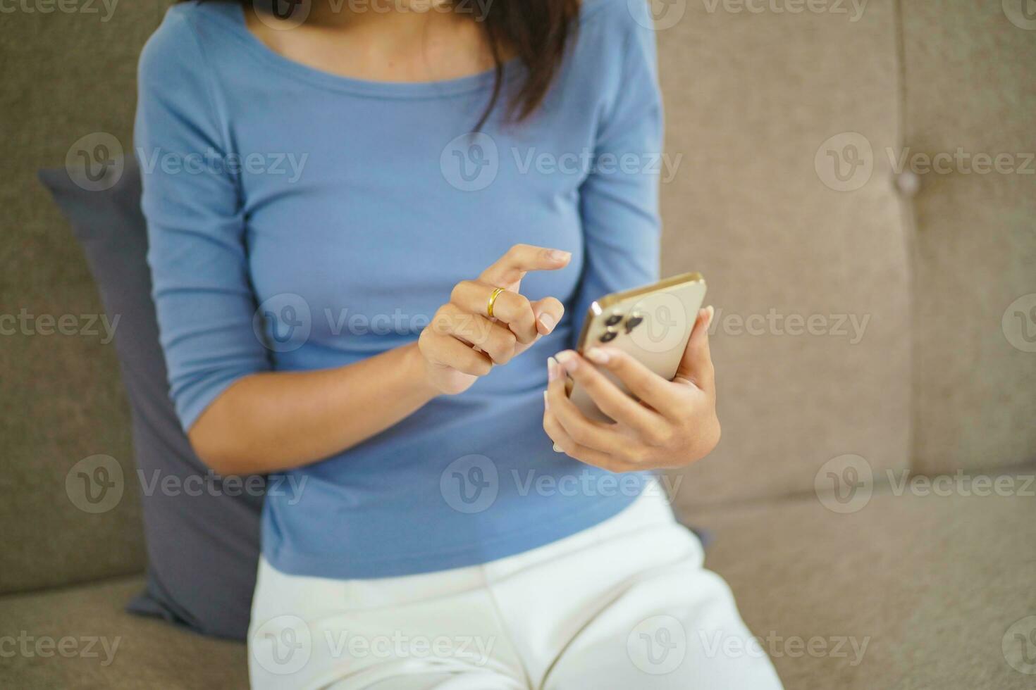 Asian Woman controlling smart home. mobile phone with smart home app in living room. touch screen ai technology. Remote home control system photo