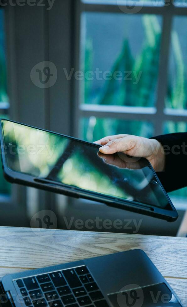 close up hands multitasking man using tablet, laptop and cellphone connecting wifi photo