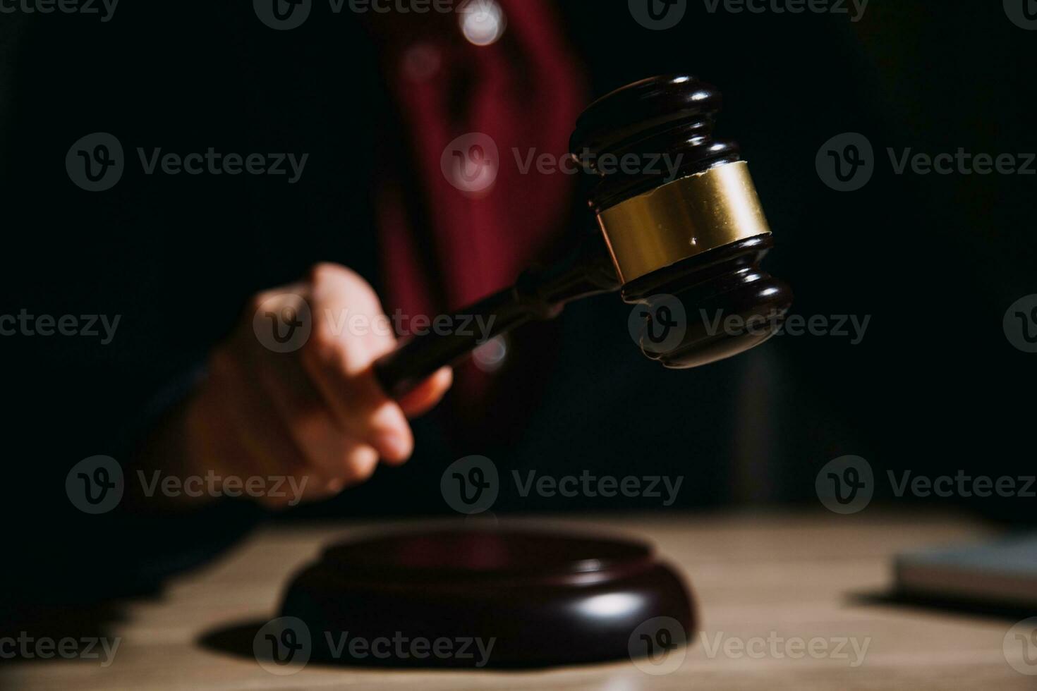 Justice and law concept.Male judge in a courtroom with the gavel, working with, computer and docking keyboard, eyeglasses, on table in morning light photo