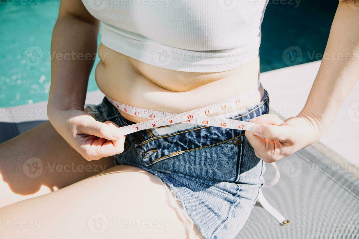 mujer gorda, barriga gorda, gordita, mujer obesa mano sosteniendo grasa abdominal excesiva con cinta métrica, concepto de estilo de vida de dieta de mujer foto