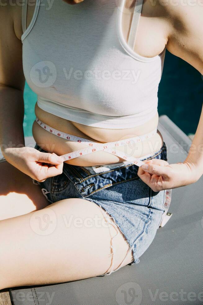 fat woman, fat belly, chubby, obese woman hand holding excessive belly fat with measure tape, woman diet lifestyle concept photo