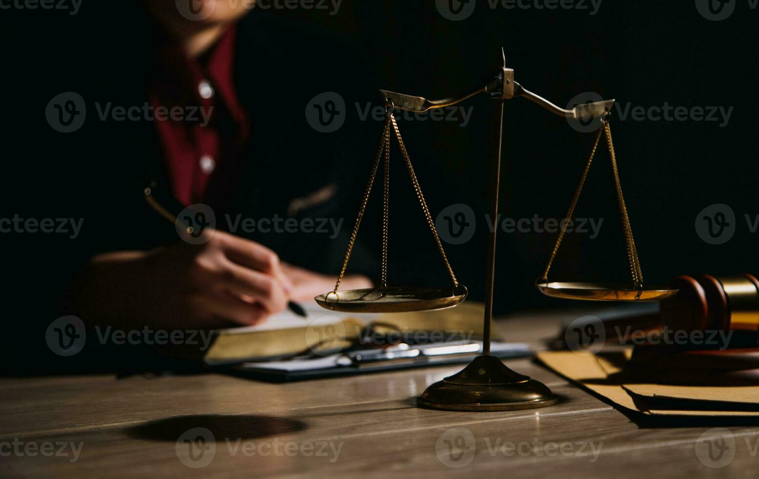 Justice and law concept.Male judge in a courtroom with the gavel, working with, computer and docking keyboard, eyeglasses, on table in morning light photo