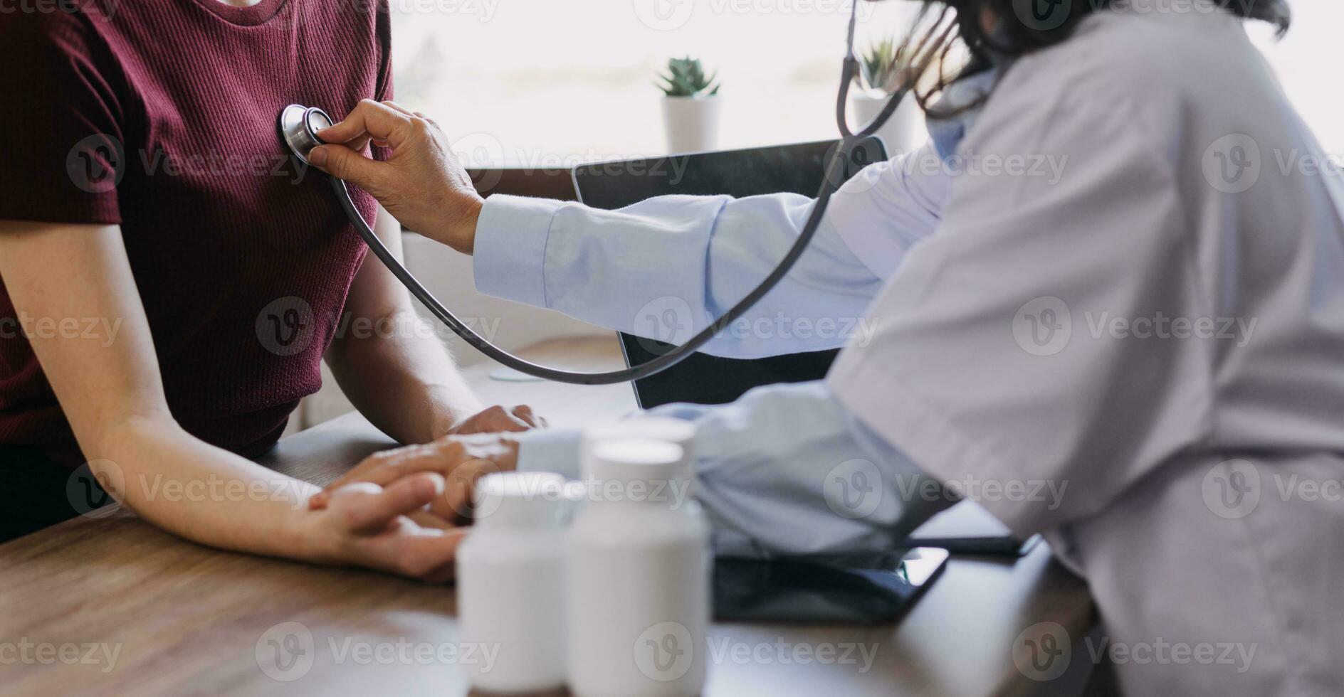 Homecare nursing service and elderly people cardiology healthcare. Close up of young hispanic female doctor nurse check mature caucasian man patient heartbeat using stethoscope during visit photo