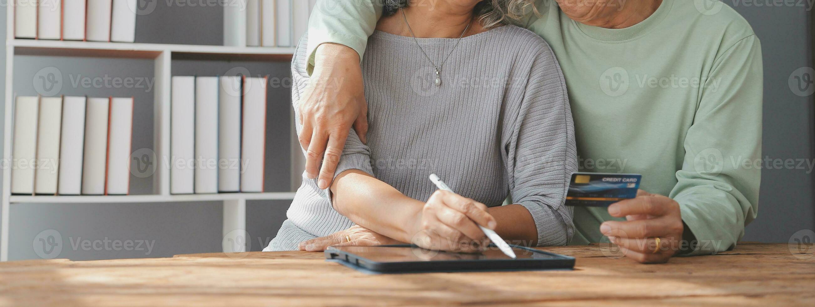 Close up mature man holding plastic credit card, senior couple family paying online, using laptop, satisfied older customers making secure internet payment, shopping, browsing banking service photo