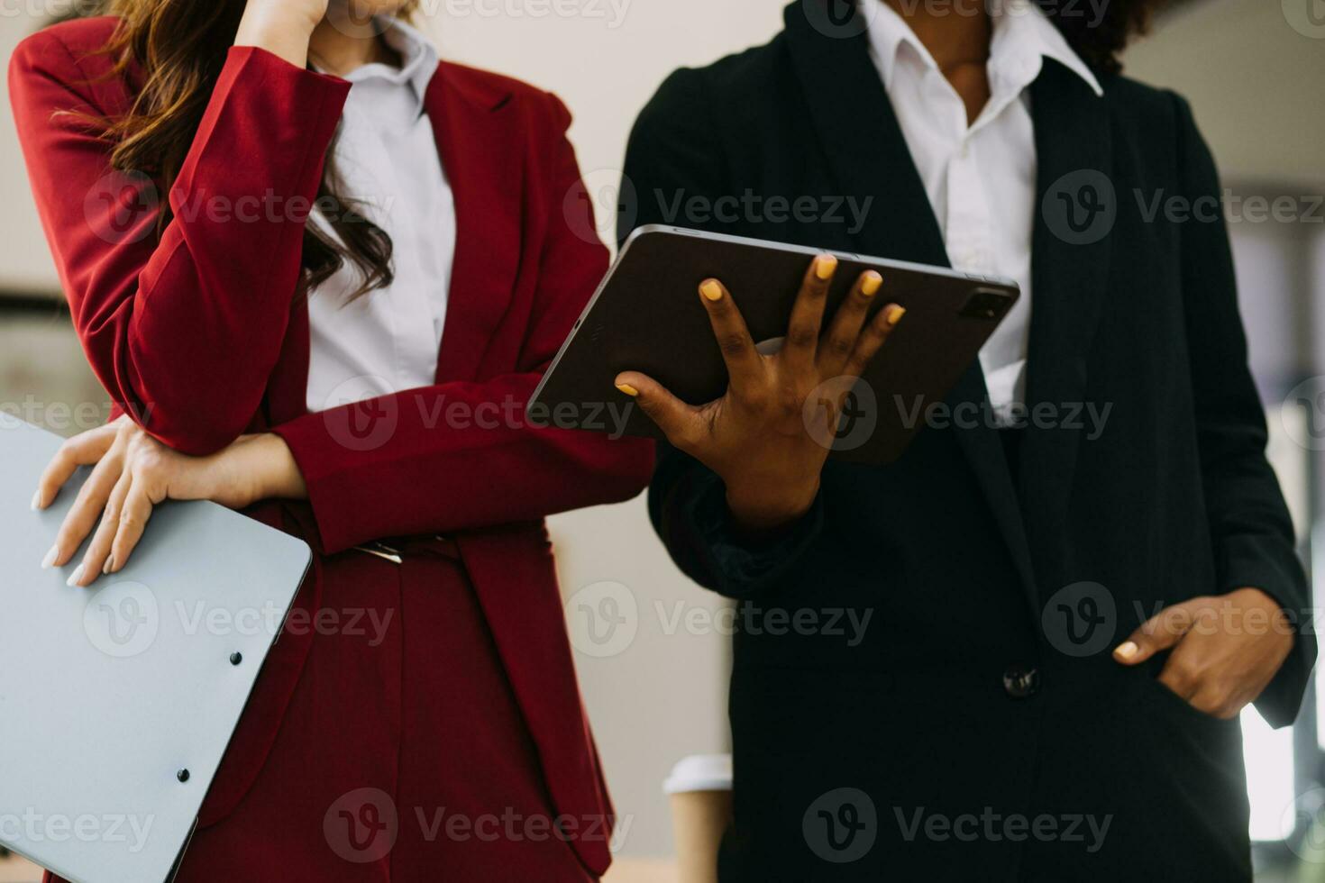 Female fashion, designer, Looking at Drawings and Sketches that are Pinned to the Wall Behind Her Desk. Studio is Sunny. Personal Computer, Colorful Fabrics, Sewing Items are Visible. photo