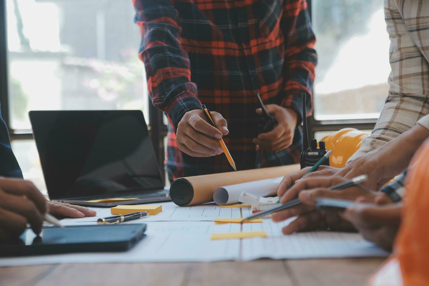 reunión de trabajo en equipo de ingenieros, trabajo de dibujo en la reunión de planos para el trabajo del proyecto con un socio en la construcción de modelos y herramientas de ingeniería en el concepto de sitio de trabajo, construcción y estructura. foto