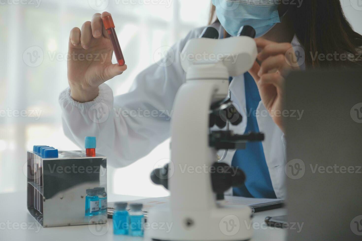 Professional lab. Amazing longhaired medical worker wearing uniform while using microscope during research photo