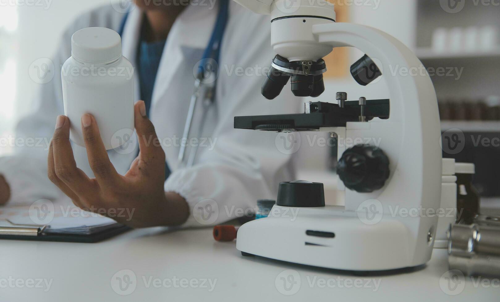 Professional lab. Amazing longhaired medical worker wearing uniform while using microscope during research photo
