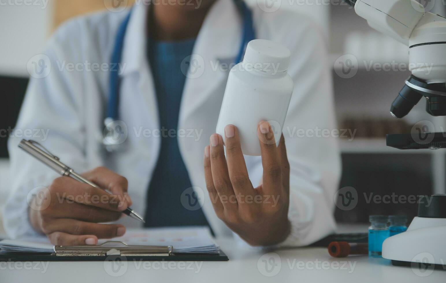 Professional lab. Amazing longhaired medical worker wearing uniform while using microscope during research photo
