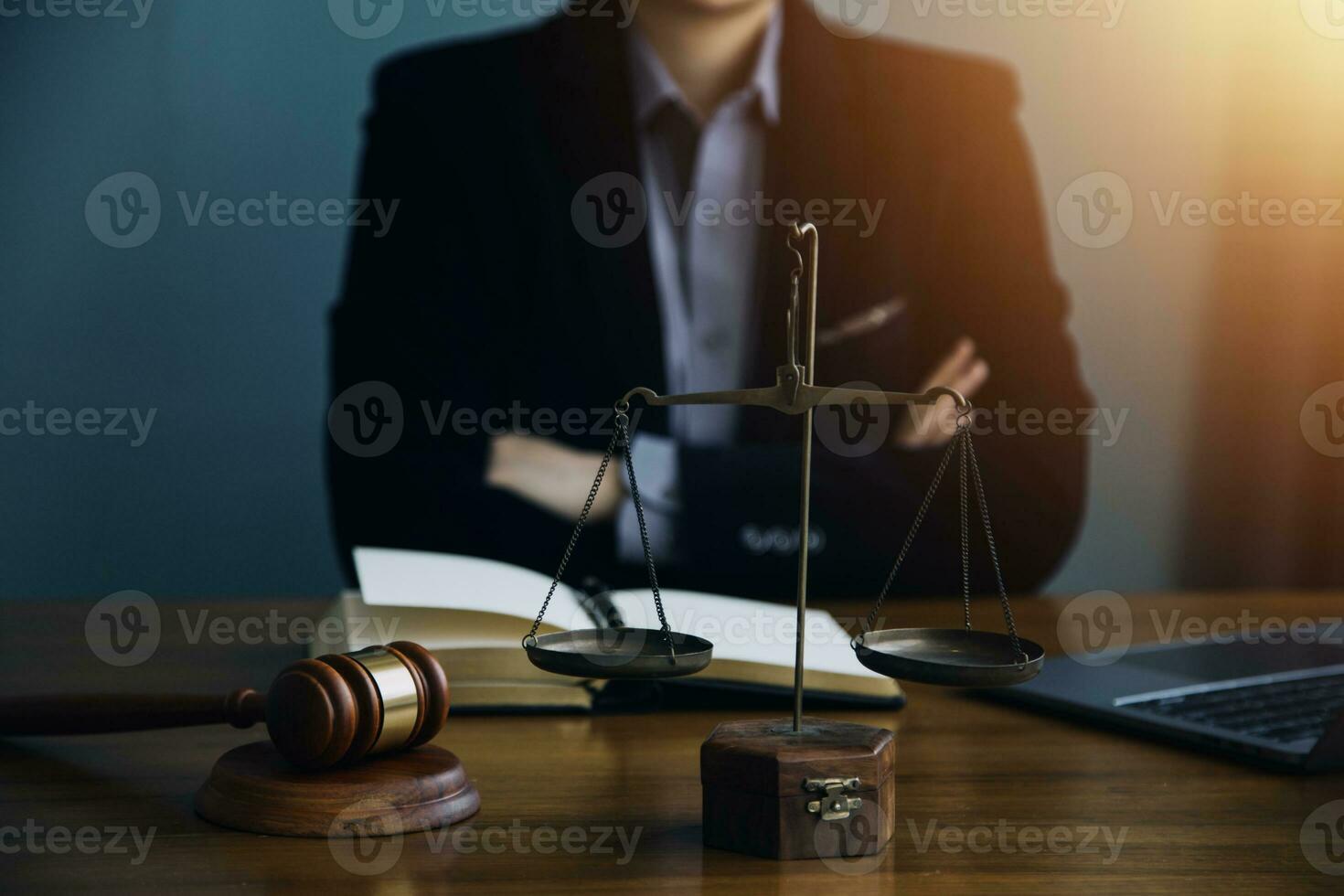 Justice and law concept.Male judge in a courtroom with the gavel, working with, computer and docking keyboard, eyeglasses, on table in morning light photo