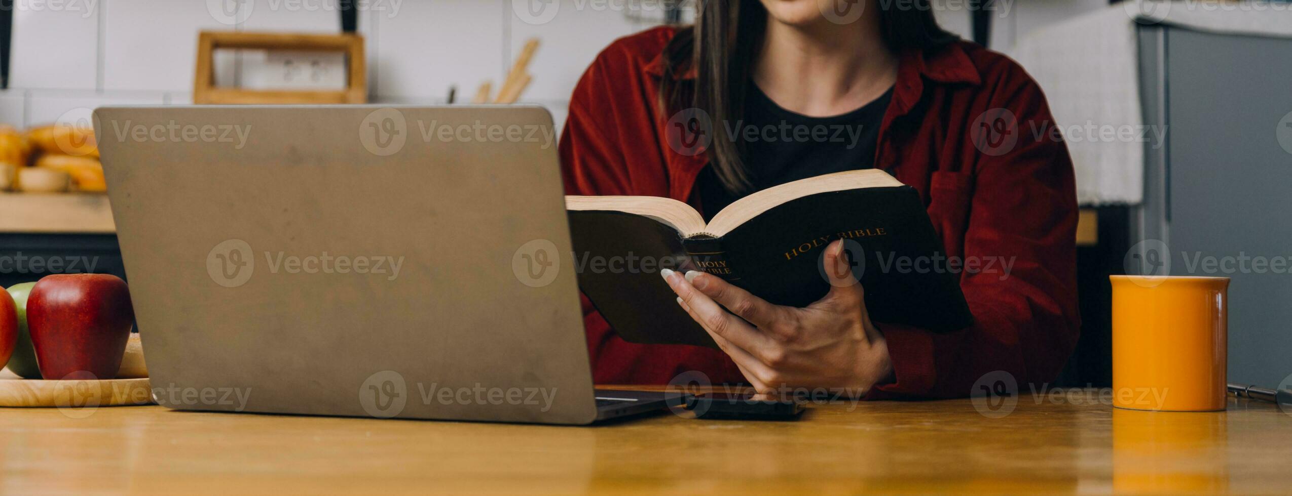 Female students note from the books at the Asian girl library sitting at sofa using laptop computer and tablet to search an online informations. in living room photo