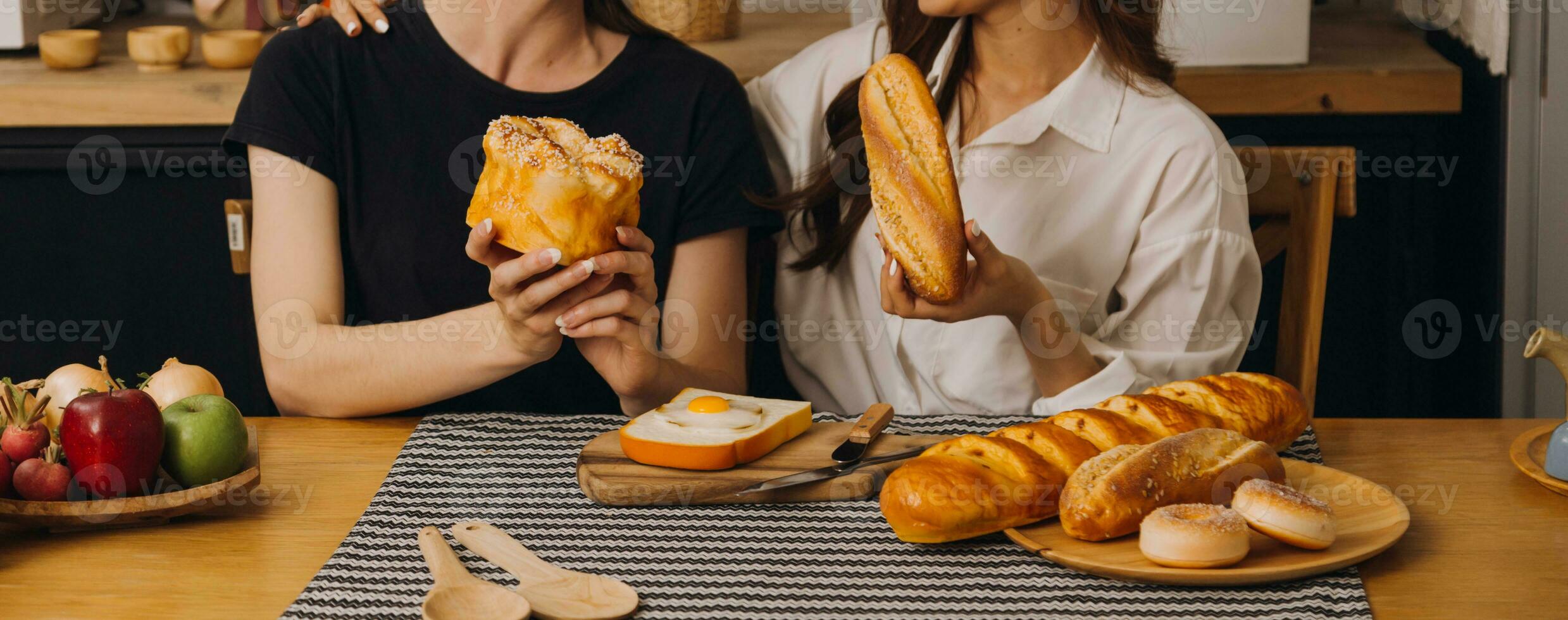 Laughing group of diverse young woman hanging out at home together and eating pizza photo