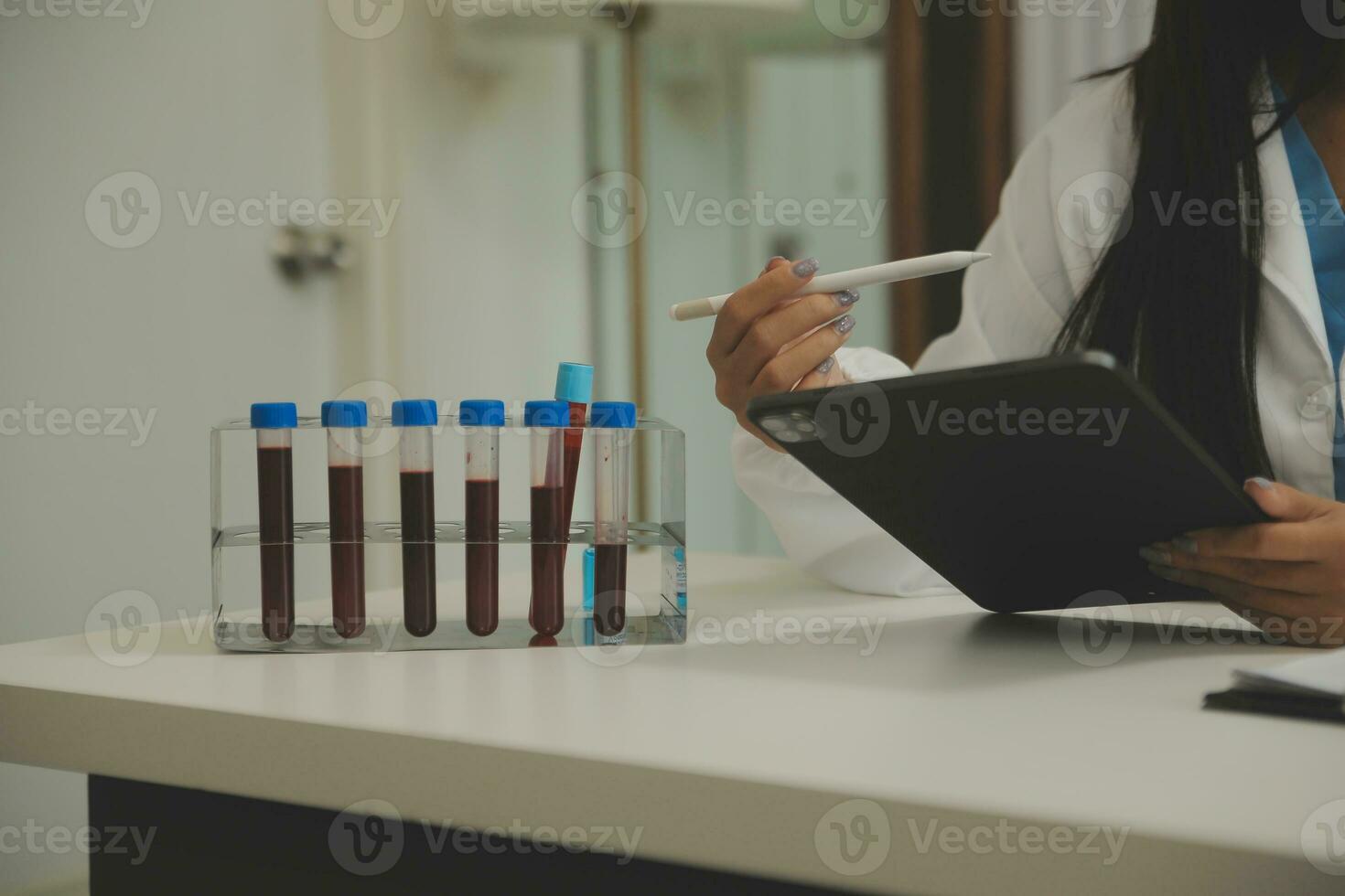 Confident doctor man holding a pill bottle and writing while talking with senior patient and reviewing his medication at office room. photo
