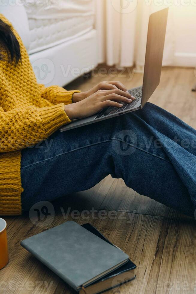 Young adult happy smiling Hispanic Asian student wearing headphones talking on online chat meeting using laptop in university campus or at virtual office. College female student learning remotely. photo