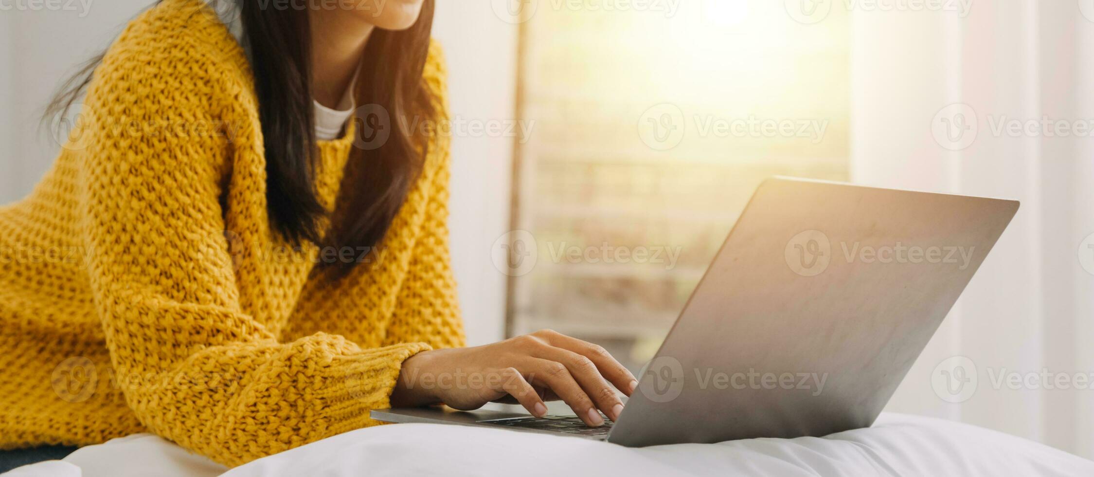 Young adult happy smiling Hispanic Asian student wearing headphones talking on online chat meeting using laptop in university campus or at virtual office. College female student learning remotely. photo
