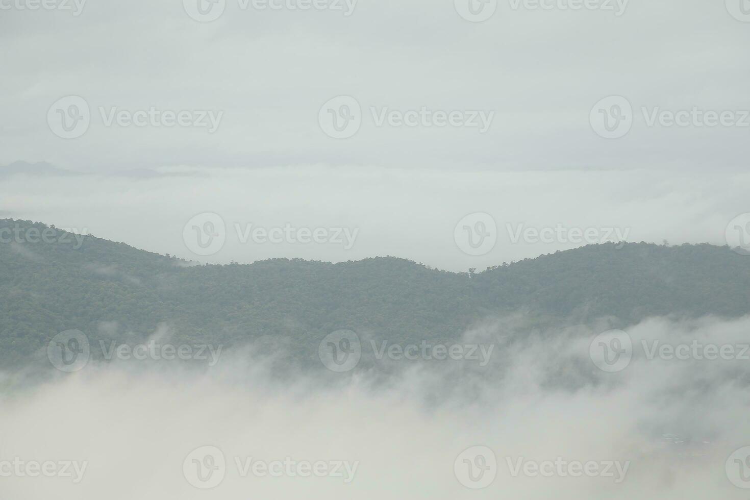 Mountain range with visible silhouettes through the morning blue fog. photo