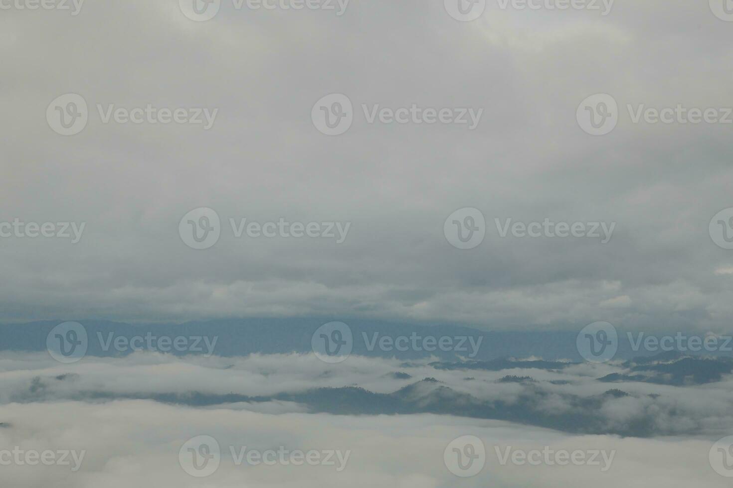 Mountain range with visible silhouettes through the morning blue fog. photo