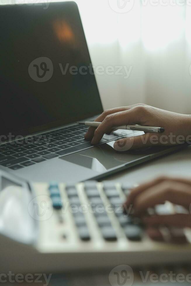 Unrecognizable businessman using calculator photo