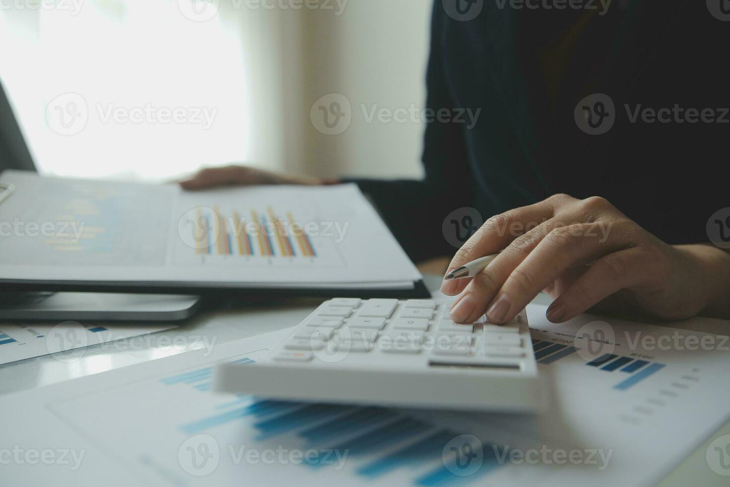 Unrecognizable businessman using calculator photo