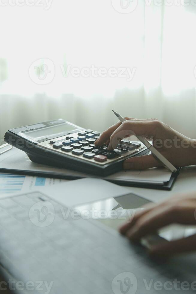 Unrecognizable businessman using calculator photo