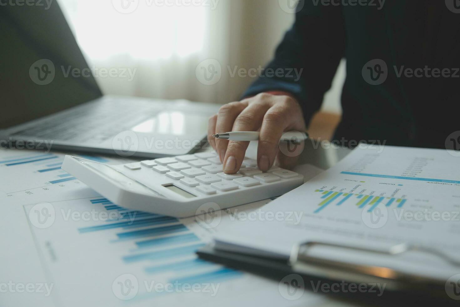Unrecognizable businessman using calculator photo