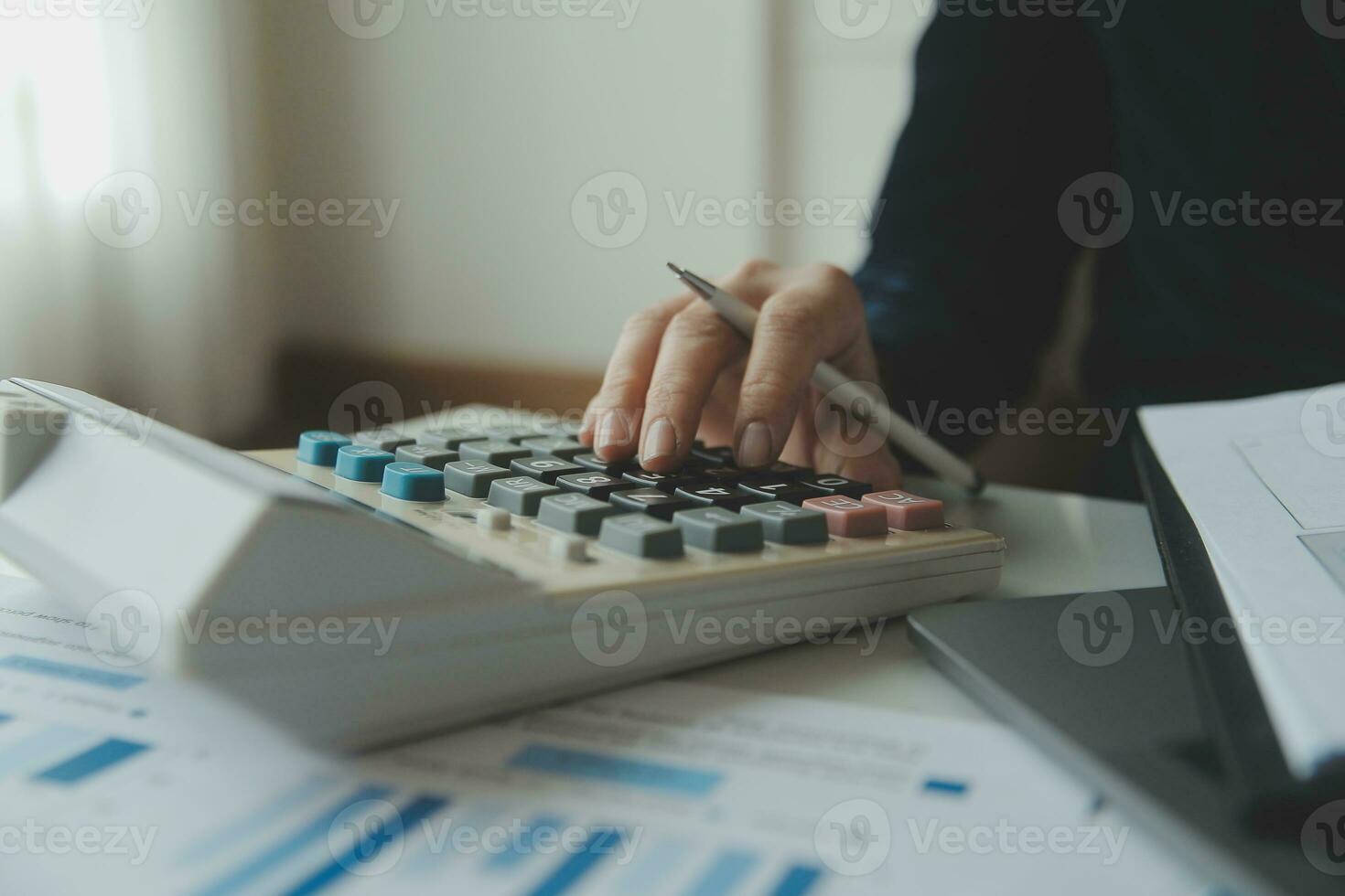 Unrecognizable businessman using calculator photo