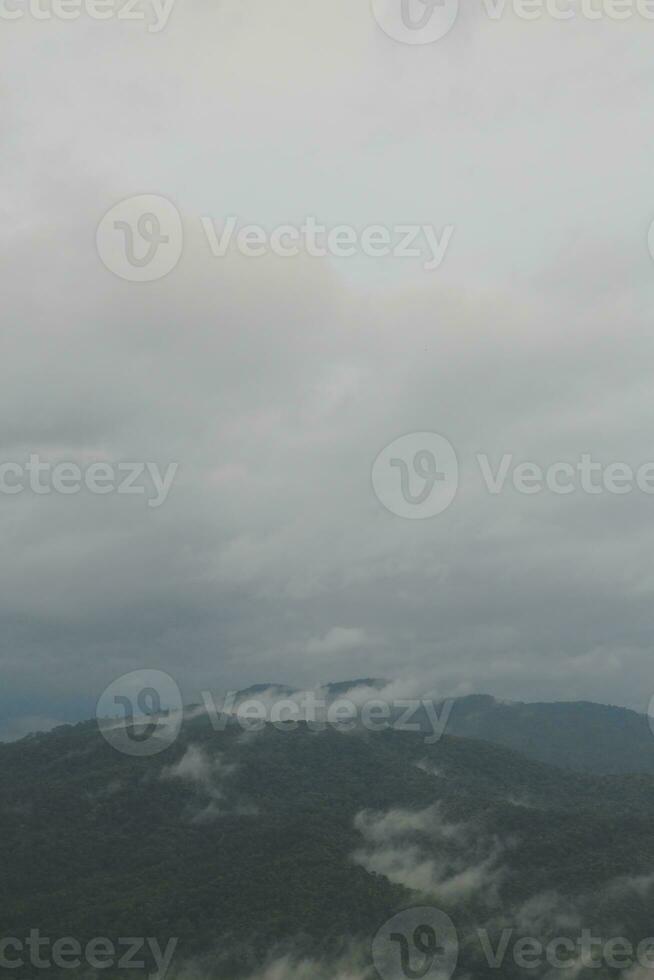 Mountain range with visible silhouettes through the morning blue fog. photo