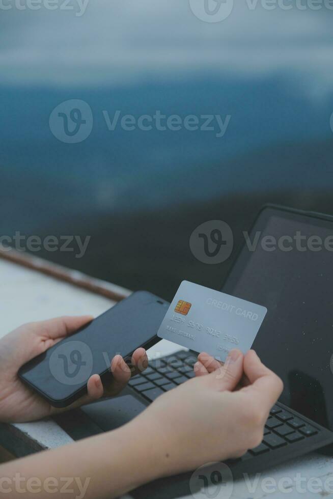 online payment, young woman holding credit card and typing on laptop photo