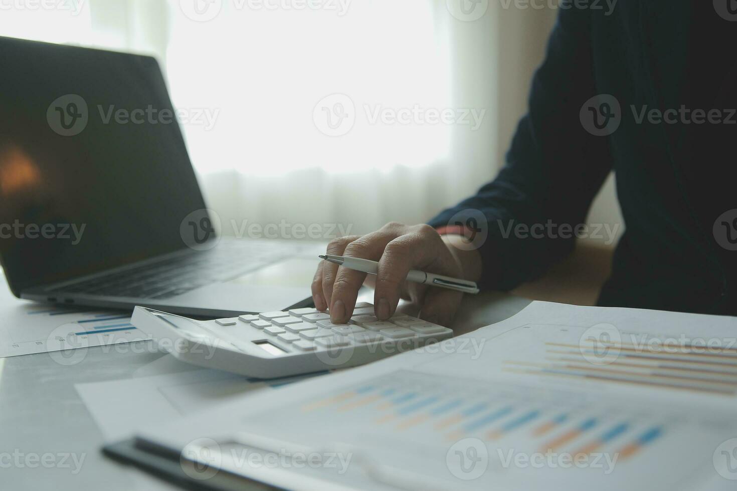 Unrecognizable businessman using calculator photo