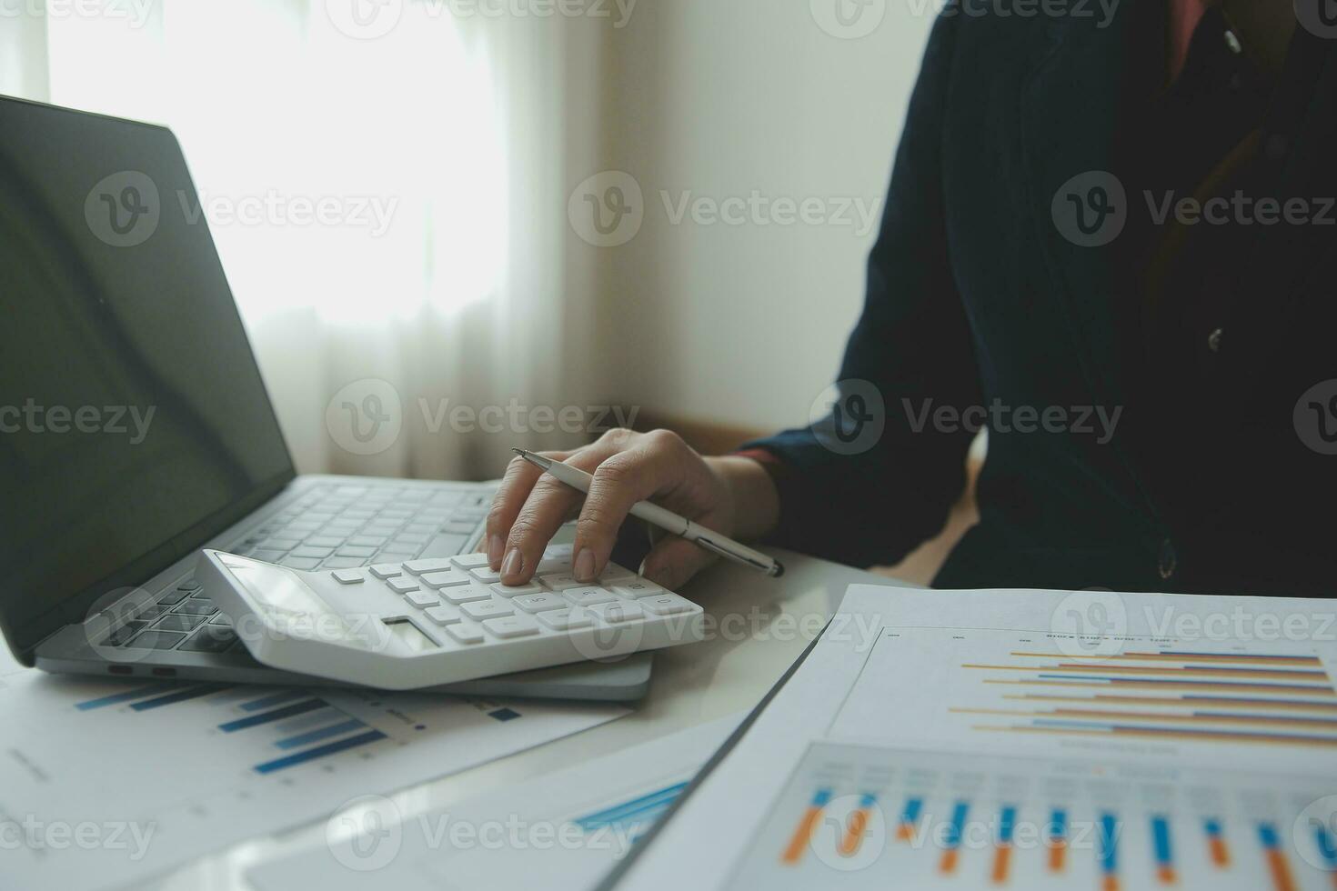 Unrecognizable businessman using calculator photo