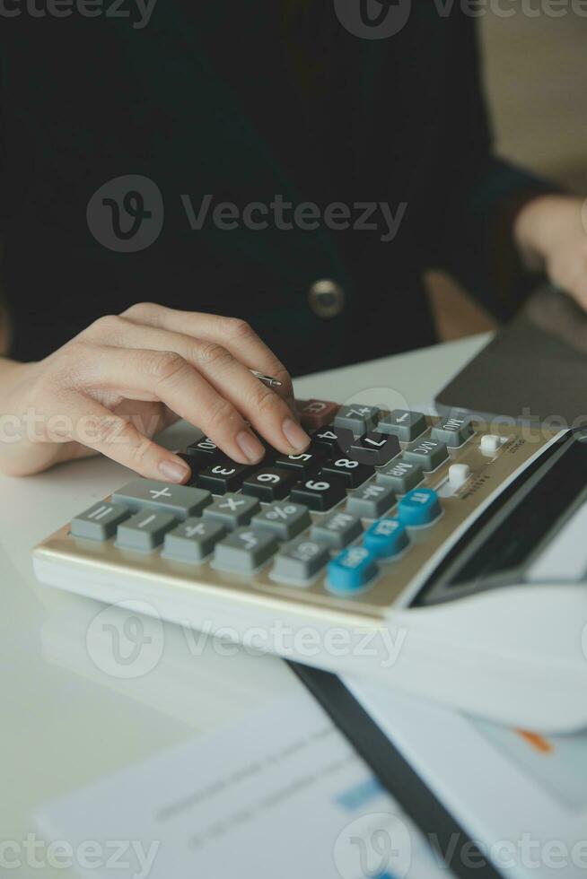 Unrecognizable businessman using calculator photo