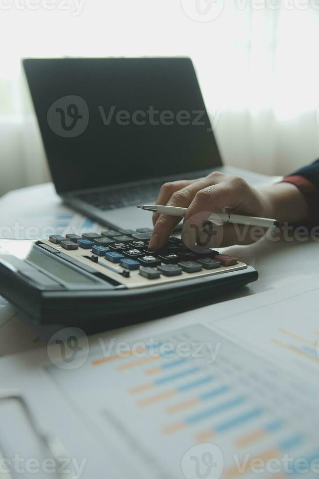 Unrecognizable businessman using calculator photo